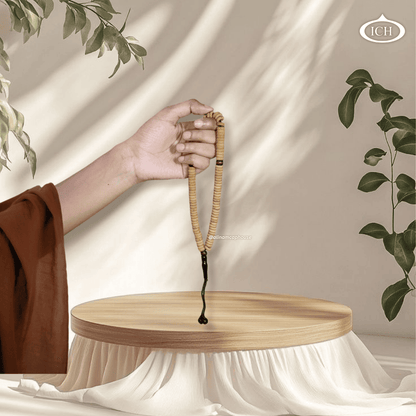Light brown Al Inam tasbih held in hand – premium Islamic prayer beads misbaha for remembrance of Allah.