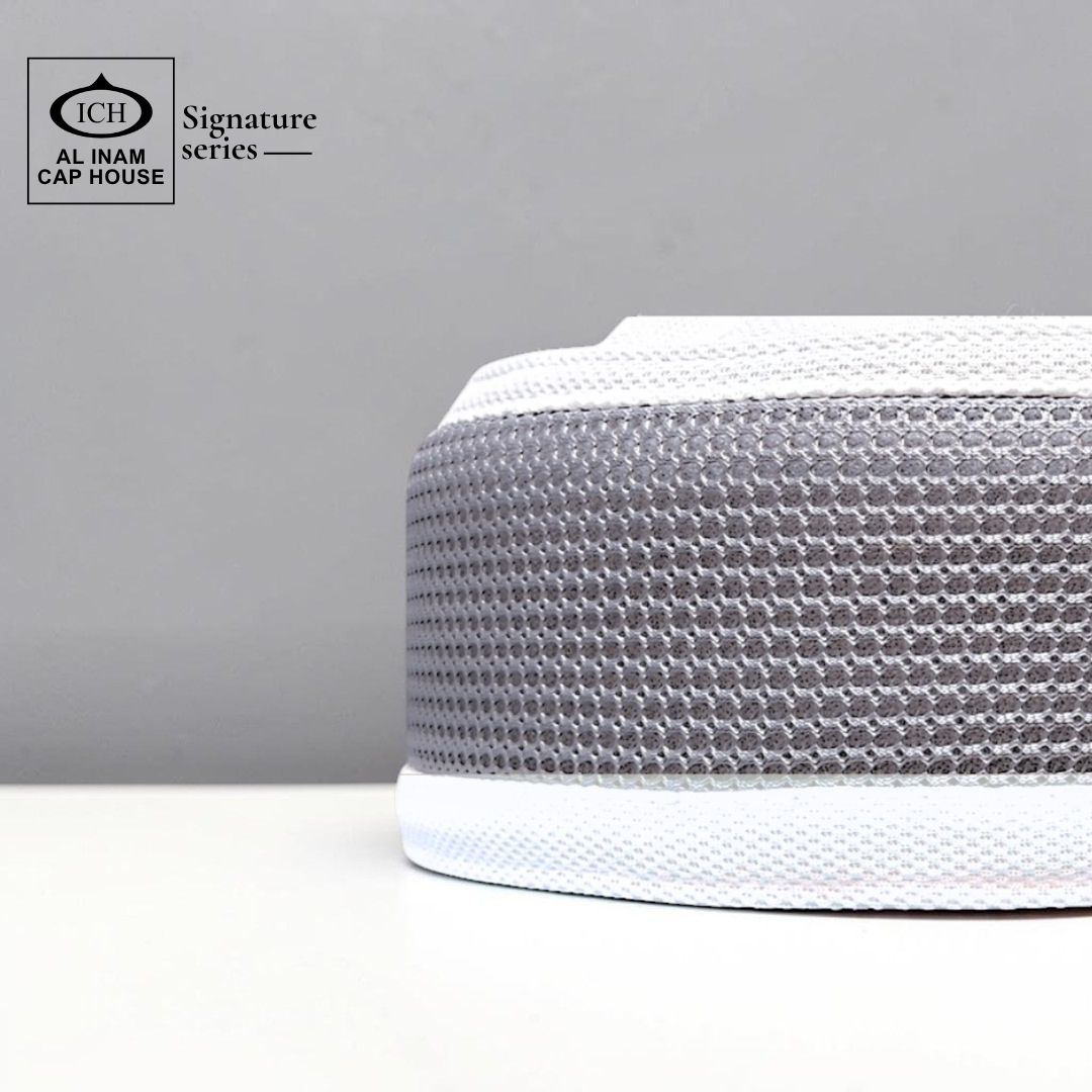 Side view of AL INAM Grey and White kufi cap showing comfortable stretch fit and smooth stitching.