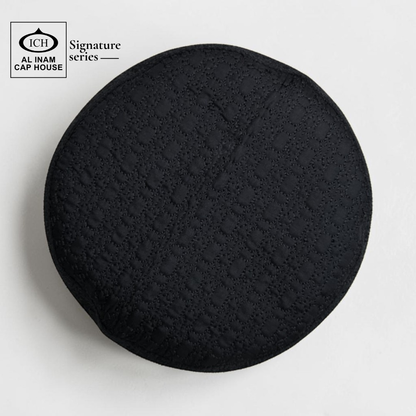 Top view of AL INAM Black Islamic Prayer Cap featuring clean textured pattern, breathable cotton construction and lightweight skull cap comfort for Muslim men.