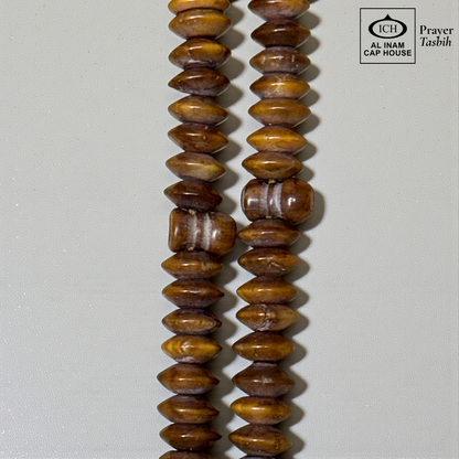 Close-up detail of AL INAM Koka Tasbih highlighting natural Kokka wood textures, polished handcrafted finish and premium Islamic dhikr beads craftsmanship with elegant grain patterns.