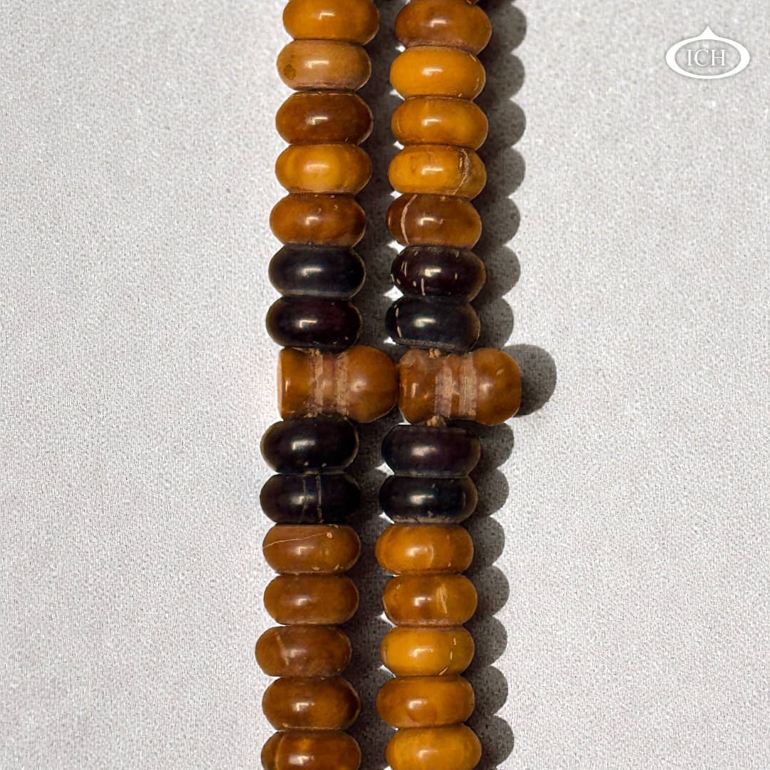 Close-up of authentic Kokka wood tasbih beads showing natural texture, rare Islamic prayer beads for dhikr.
